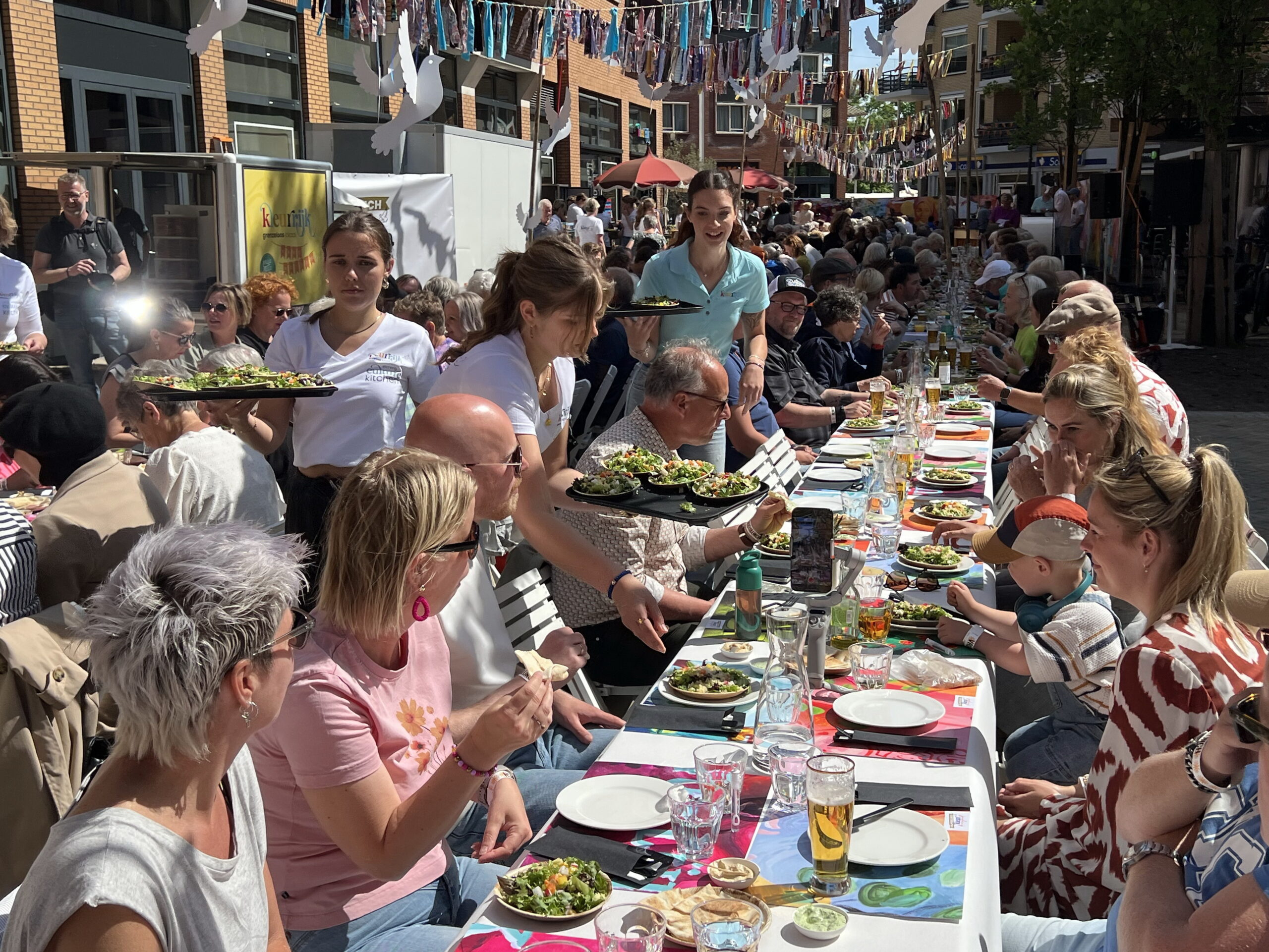 Bewogen toespraak bij Kleurrijk-lunch voor 300 mensen aan lange tafels in het centrum